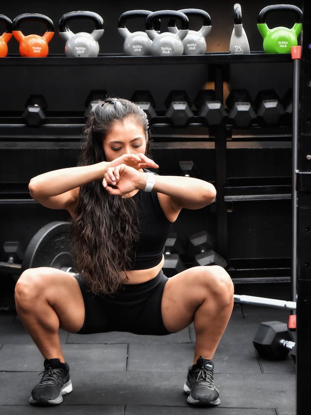 a girl deep squat inside gym