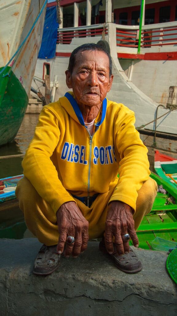 an old man asian squat on wall